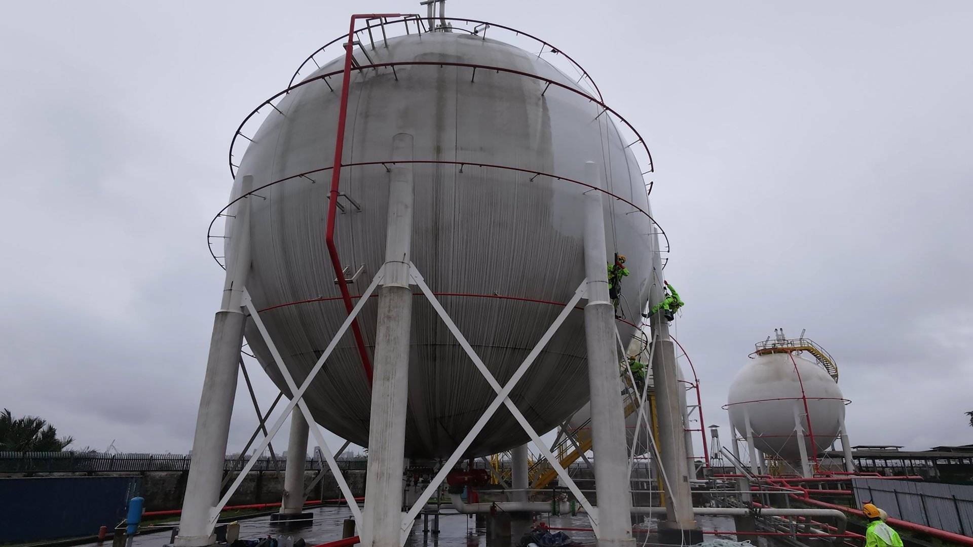 Réservoir sphérique de stockage de gaz avec agents de maintenance sur un site de la SCDP